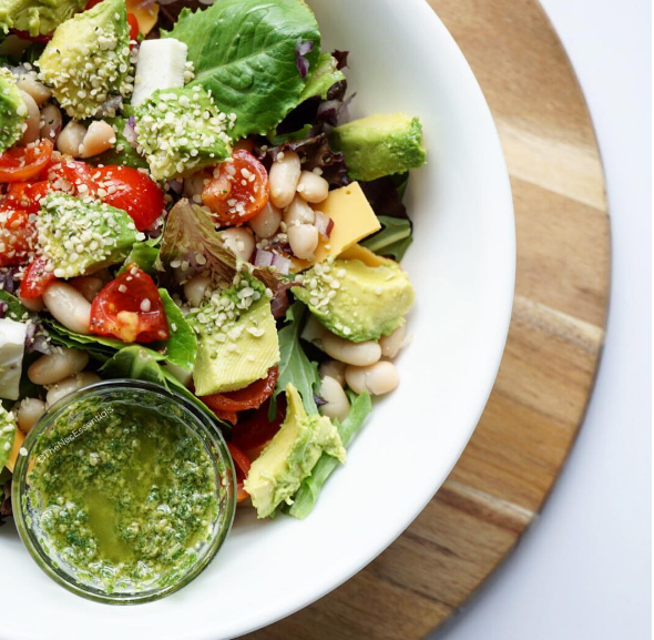 "One of my favorite salads mixed greens + grape tomatoes + avocado + @manitobaharvesthemp hearts + great northern beans + purple onion + @followyourheartcheddar cheese + Lisanatti mozzarella cheese + @jeffsnaturals kalamata olives + homemade pesto dressing (link in bio) mixed w/ dijon mustard and olive oil (salt and pepper optional). Enjoy!" - Shared by Instagram user @thenecessentials